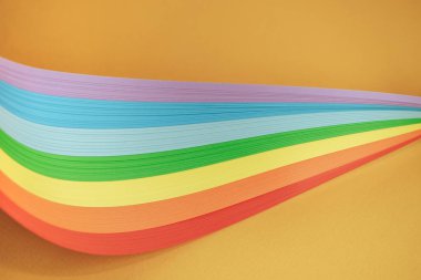 Turuncu arkaplanda güzel gökkuşağı renk kurdelesi.