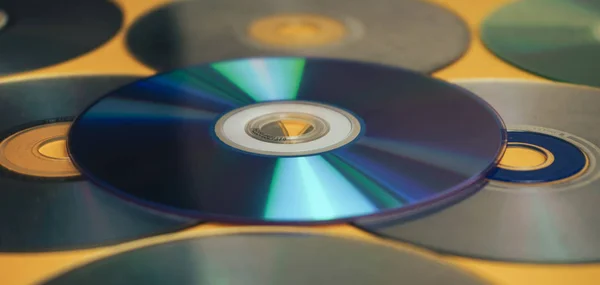 美しい古い汚れたCdを閉じます 黄色の背景にDvd — ストック写真