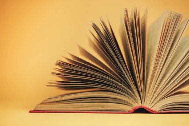 Sarı arka planda güzel, açık kırmızı bir kitap.
