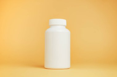 Sarı arka planda haplar için beyaz şişe..
