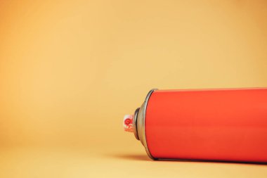 Kırmızı balon Aerosol boyası sarı arka planda yakın plan.