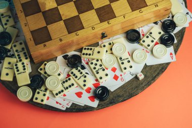 Çeşitli masa oyunlarını kapat, satranç tahtası, kart oyna, eski tahta masa şeftalisi arka planında domino oyna..