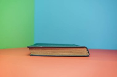 Kırmızı masa ve yeşil mavi arkaplan üzerine kitap.
