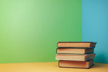 Sarı masa ve mavi duvar arkaplanı üzerinde açık güzel bir kitap..
