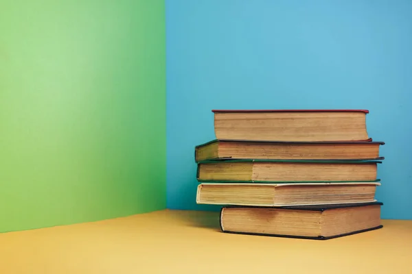 Beautiful open book on a yellow table and blue green wall background.