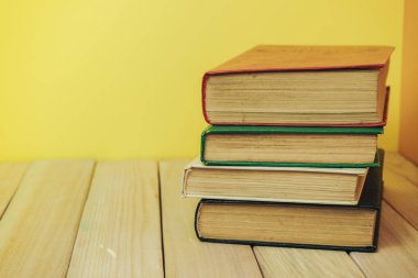 Ahşap bir masada güzel bir kitap ve sarı turuncu bir arka plan..