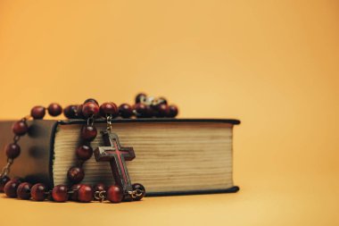 İncil 'i sarı bir arka plan masasında eski boncuklarla kapat. Din kavramı.