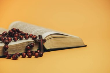 Sarı arkaplan masasında eski boncuklarla Kutsal Kitap 'ı aç. Din kavramı.