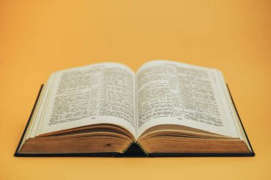 Sarı bir arkaplan masasında kutsal kitabı aç. Din kavramı.