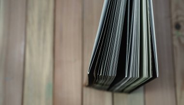 Ahşap masa arkaplanındaki yeni ve güzel kitabı kapat. Üst görünüm.