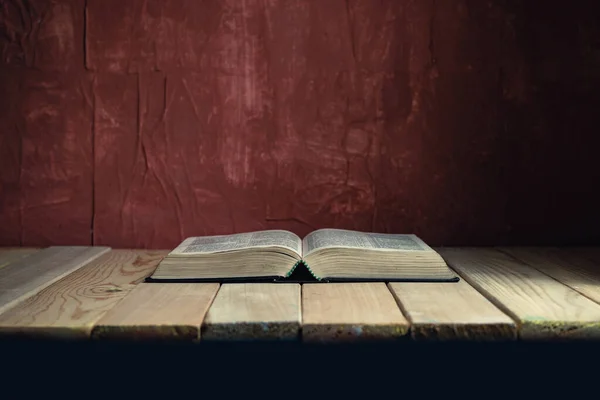 Open Holy Bible Old Wooden Table Beautiful Red Wall Background —  Fotos de Stock