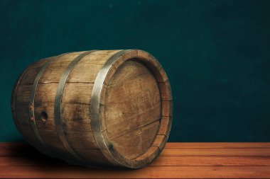 Beautiful wooden barrel on a red wood table and green  wall background.	