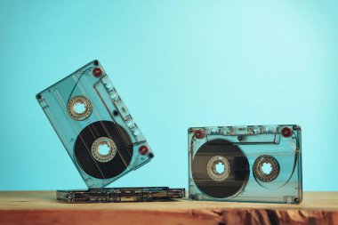 Kırmızı ahşap bir masa ve mavi bir alanda güzel bir ses kaseti. Minimalizm retro tarzı konsept. 80 'ler. Tasarım için arkaplan deseni.