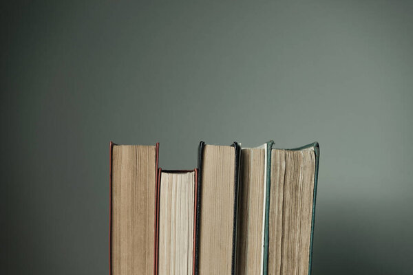 Beautiful open books on a old red wooden table and white wall background.
