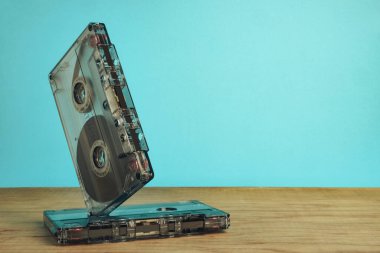 Kırmızı ahşap bir masa ve mavi bir alanda güzel bir ses kaseti. Minimalizm retro tarzı konsept. 80 'ler. Tasarım için arkaplan deseni.