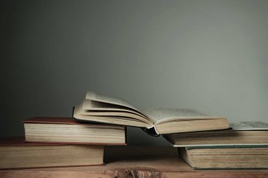 Eski kırmızı ahşap bir masa ve beyaz bir arka plan üzerinde güzel açık kitaplar..