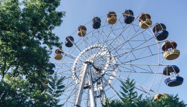 Mavi gökyüzü arka planındaki lunaparkın güzel renkli dönme dolabı.