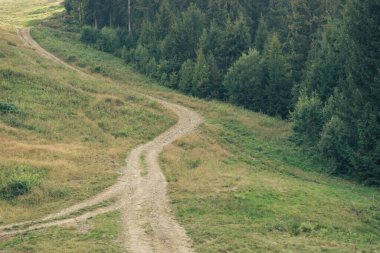 Carpatian yaz manzarası. Dağlardaki toprak yol. Mavi arkaplanda güzel dağlar.