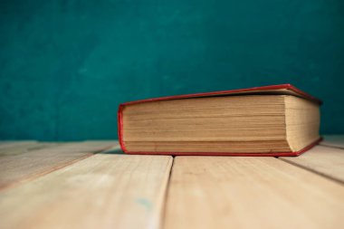 Güzel, eski, bulutlu, kırmızı ahşap bir masa ve arkasında koyu yeşil bir duvar..