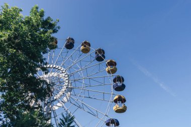 Mavi gökyüzü arka planındaki lunaparkın güzel renkli dönme dolabı.