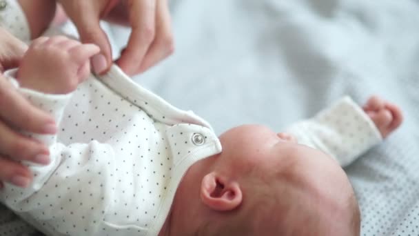 Egy fiatal anya undresses neki újszülött baba, megcsókolja őt szelíden. Anyák ellátás, anya és a baba — Stock videók