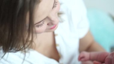 Anne ve çocuk. Anne sakinleşir, ağlayan yeni doğmuş bir bebeği kucağına alır. Anneler Günü