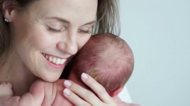 Bir mutlu olgun anne kucağında yeni doğmuş bir bebek ile yakın çekim portre. Mutlu annelik. Anneler günü. Dikkatli annelik