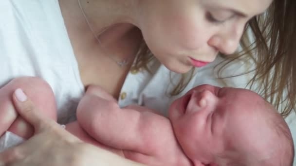 Um bebê recém-nascido chora nos braços de sua mãe. Cólica em recém-nascidos. A mãe acalma o bebé chorão. Saúde do recém-nascido — Vídeo de Stock