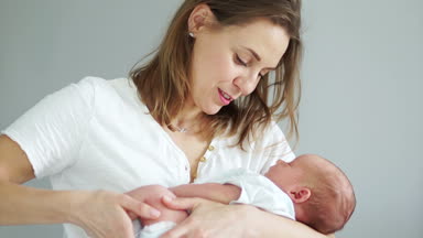 Mutluluk anne holding yeni doğan bebek kollarındaki Close-up. Mutlu annelik, anne ve çocuk, Bebek uyuyor. Anneler günü