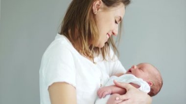 Genç bir anne kucağında uyuyan onun yeni doğan bebek tutar. Surrogacy. Tüp bebek. Tüp Bebek