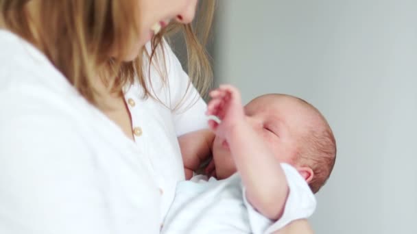 Ein Neugeborenes schläft in den Armen seiner Mutter ein. winkt im Traum mit der Hand. Mutter und Kind. Muttertag — Stockvideo