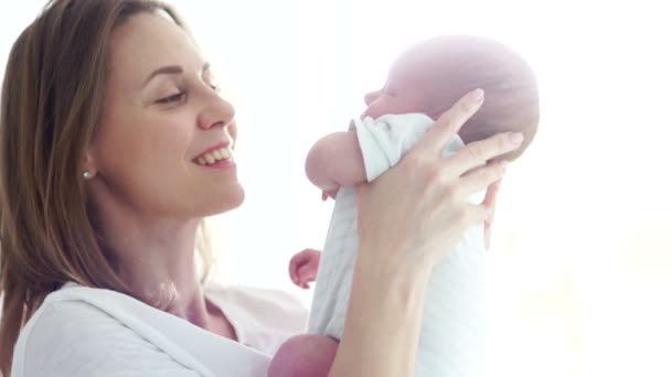 Μια ευτυχισμένη μητέρα κρατά ένα δύο-εβδομάδα-παλαιό μωρό στην αγκαλιά της. Ευτυχισμένος μητρότητα. Ημέρα της μητέρας — Αρχείο Βίντεο