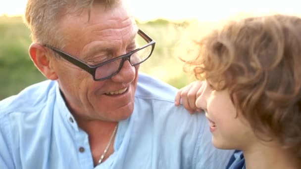 Nahaufnahme Porträt von Großvater und Enkel. Zwei Generationen haben Spaß in der Natur - lachen und albern herum. glücklicher Familienurlaub — Stockvideo