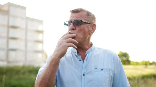 A mature man nervously smokes. Harm to smoking. With anger throws a cigarette on the ground — Stock Video