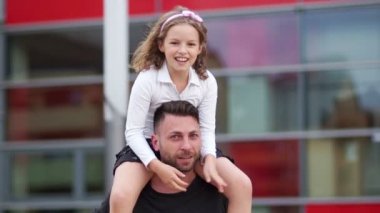 Baba ve kızı, mutlu bir aile. Kız adam omuzlarında oturur, neşeyle gülüyor ve taraf için kollarını yayılır