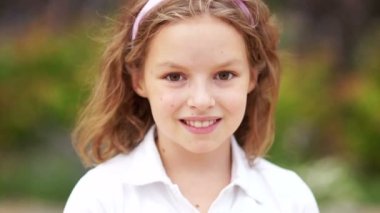 Küçük bir sarışın kahverengi gözlü sevimli kız yüzünü kapat. Gözleri yanıp sönen ve gülümseyen kız. İçeride. Portre vurdu. Mutlu kız öğrenci