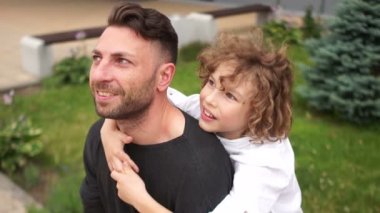 Baba ve oğul gökyüzüne bakıyor. Oğlu olan genç bir adam parkta eğleniyor. Mutlu aile hafta sonu