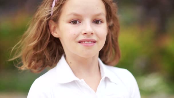 Curly brown-eyed girl teenager looks at camera and smiles. He manages his hair. Fresh natural beauty — Stock Footage Curly brown-eyed girl teenager looks at camera and smiles. He manages his hair. Fresh natural beauty Royalty Free Stock Video