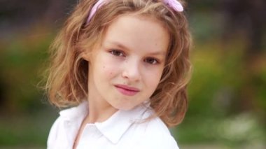 Yarım dönüş portre. Kız kameraya omzunun, sakin ve samimi bir görünüm görünüyor. Genç coquette