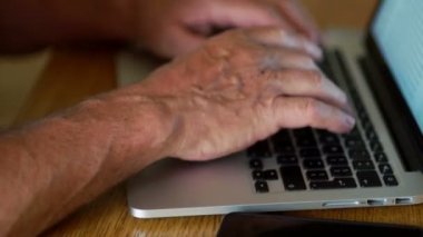 Bilgisayar klavye ile çalışan emekli el kapatın. Internet bankacılığı, dizüstü bilgisayar, modern araçlar ve emeklilik yaşı insan