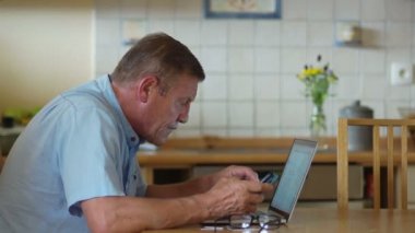 Emeklilik yaşı biri bir dizüstü bilgisayar ve bir telefon kullanır. O dikkatle bilgisayar ekranında görünüyor, söylüyorsun, Gözlük, miyopluk Giydir