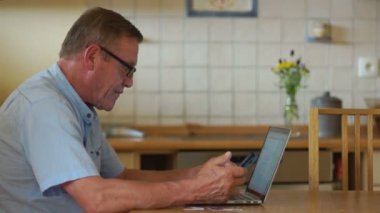 Büyükbaba Internet'te faturaları ödüyor. Telefon genel kavram. Online alışveriş. Sakin bir emeklilik, yaşlılık Dengeleme
