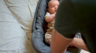 Güzel bir bebek bir araba koltuğuna konur. Çocukların güvenliği için arabada. O onun emniyet kemeri bağlamamak iken çocuk yakından babasına benziyor