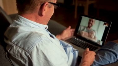 Emeklilik yaşı. Bir oğlu onun kollarında bir bebekle Skype yaşlı babasını arıyor. Mutlu aile, babalar günü.