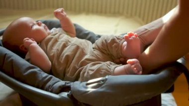 Bir iki aylık çocuk bir şey koymak ve emniyet kemeri bağlanır. Çocuk sakin bir şekilde görünüyor