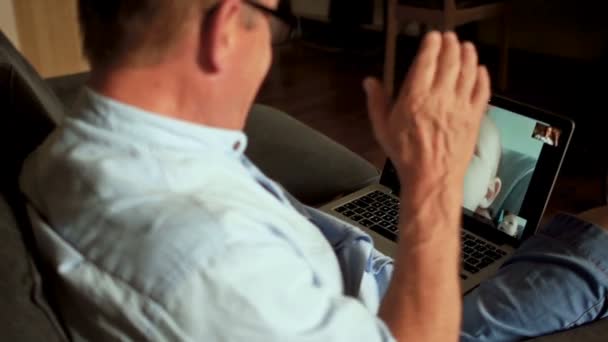 Grootvader golven zijn hand aan zijn weinig kleinzoon. Video-oproep op Skype, gelukkige familie. Drie mannen, drie generaties van dezelfde familie, moderne technologie, internettechnologie — Stockvideo