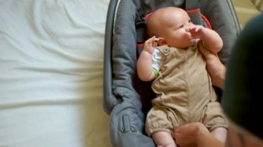 Araba koltuğu çocuk. Ağzına bir emniyet kemeri almaya çalışıyor. Dişler kesilir, sakız kaşınıyor. Çocukların gelişimini bir yıl yaş altında