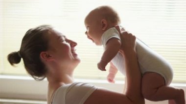 Yeni doğmuş çocuğunu tutan genç anne. Anne bakım bebek. Kadın ve yeni doğan çocuk yatak odasında rahatlayın. Meme besleme bebek anne. Aile evde