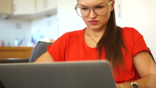 ノート パソコンのモニターの背後に働く赤で女性の肖像画。美鈴、女性フリーランサー、秘書、オフィスの従業員、マネージャー。光学ガラスを身に着けている女の子 — ストック動画