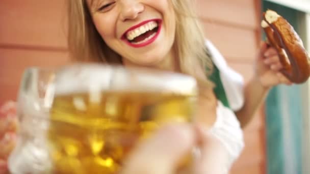 Alcoholic intoxication, a young girl drinks beer at the octoberfest festival, she is very cheerful and laughs loudly. Dressed in a Bavarian costume — Stock Video